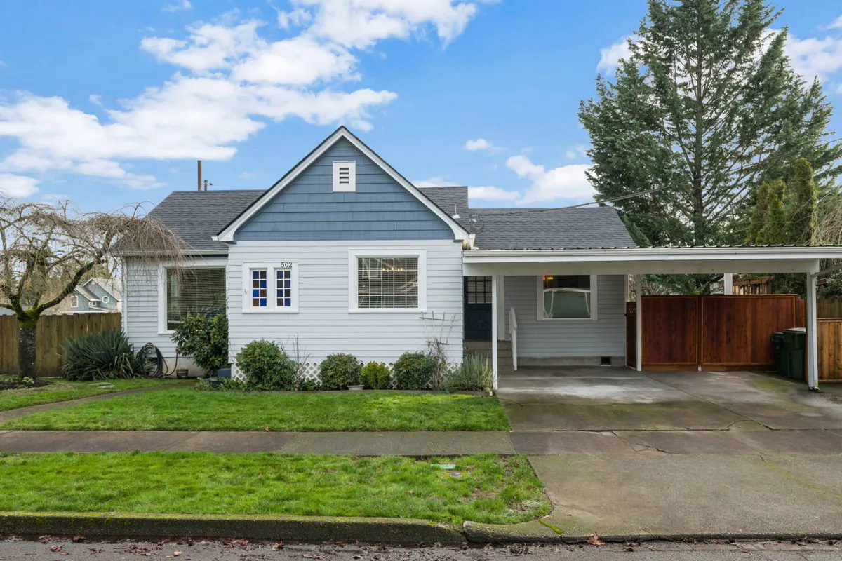 An exterior shot featuring cheerful blue siding, a landscaped garden, and a family-friendly front porch. The scene suggests a vibrant, welcoming neighborhood environment, ideal for relaxing mornings or evening strolls.