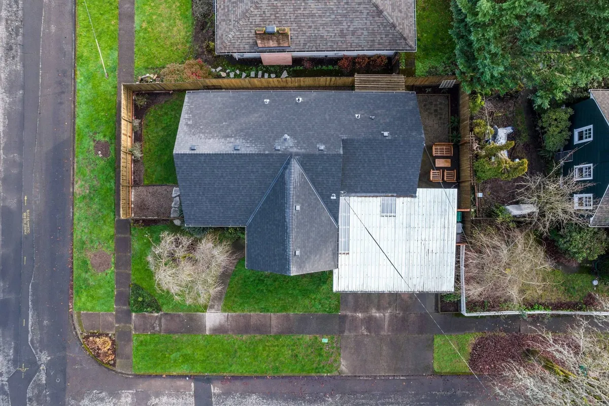 This exterior image showcases the home's backyard deck, detailed rooflines, and well-maintained landscaping. The deck offers a clear view of an inviting outdoor space perfect for relaxation, outdoor dining, and family gatherings. The sense of privacy and open space suggests a safe environment for pets and children to play.