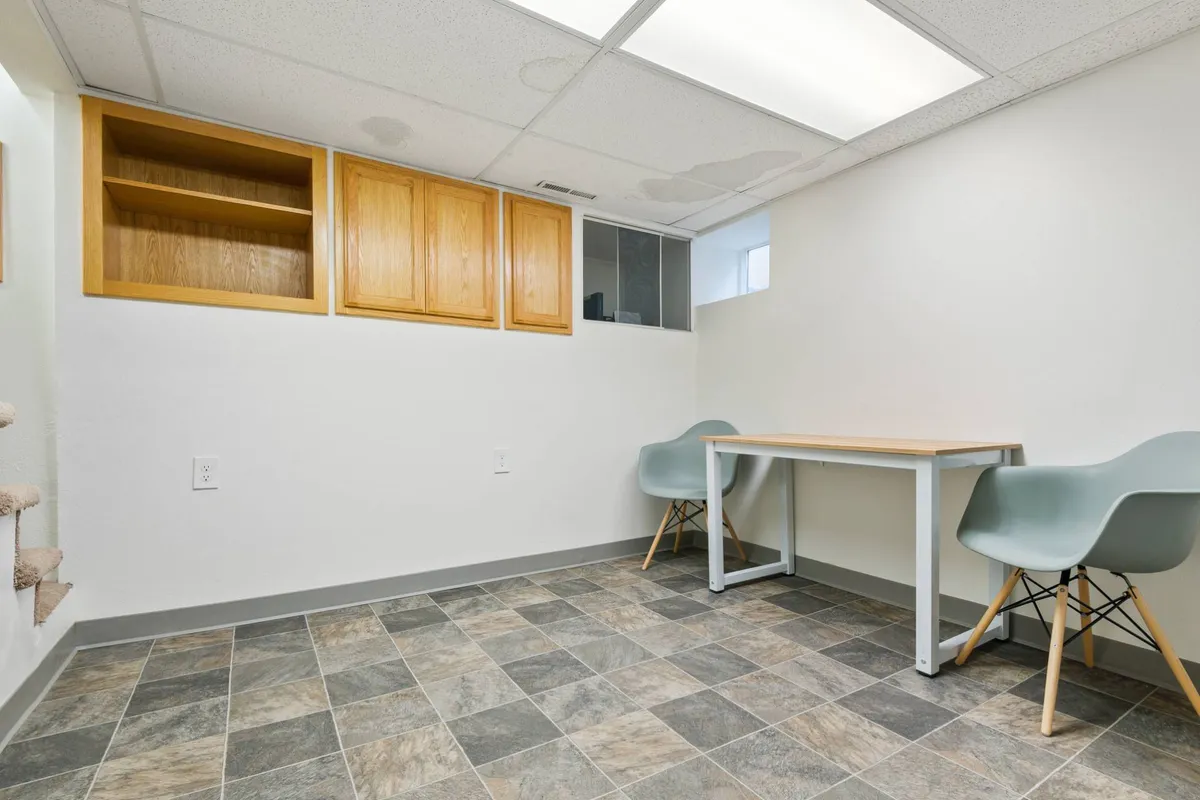 This image features a simple table and chairs set up beside shelves, creating a focused, uncluttered space ideal for work, study, or creative pursuits. The neutral tones foster a productive environment.